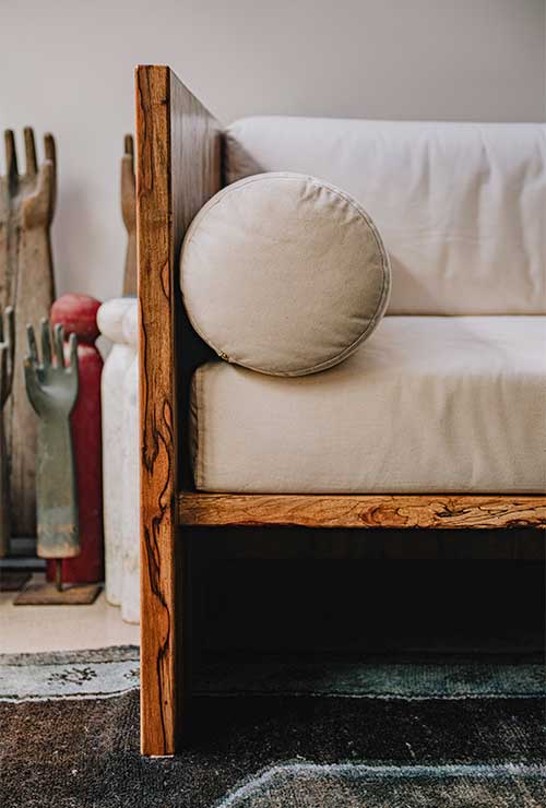 The Sofa's solid pecan slabs contrast with the 10.10oz American canvas upholstery.